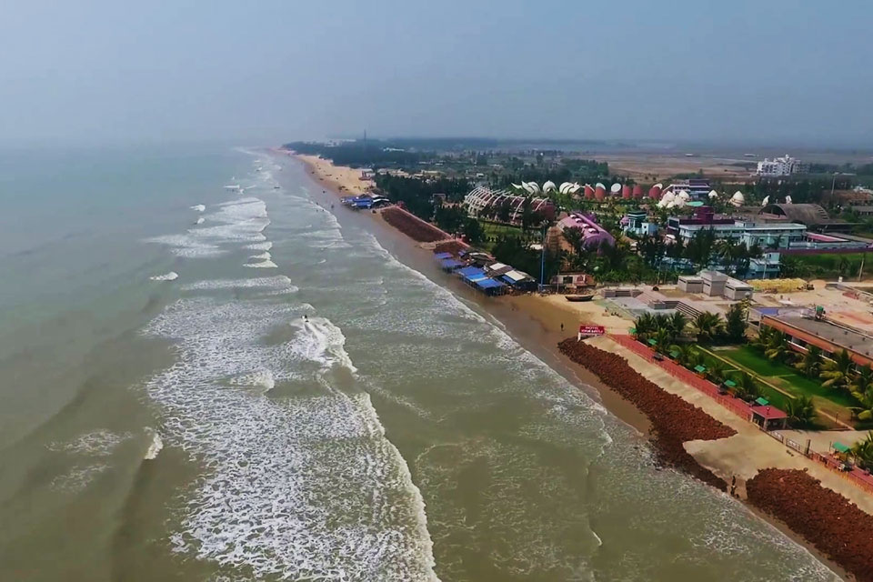 a bird eye's view of mandarmani beach with various resorts and hotel on the coastline