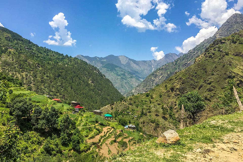 a few homestays seen atop hills in the sainj valley in the himalayas