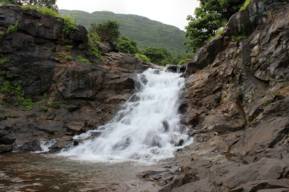 small tamhini ghat waterfall gushing down