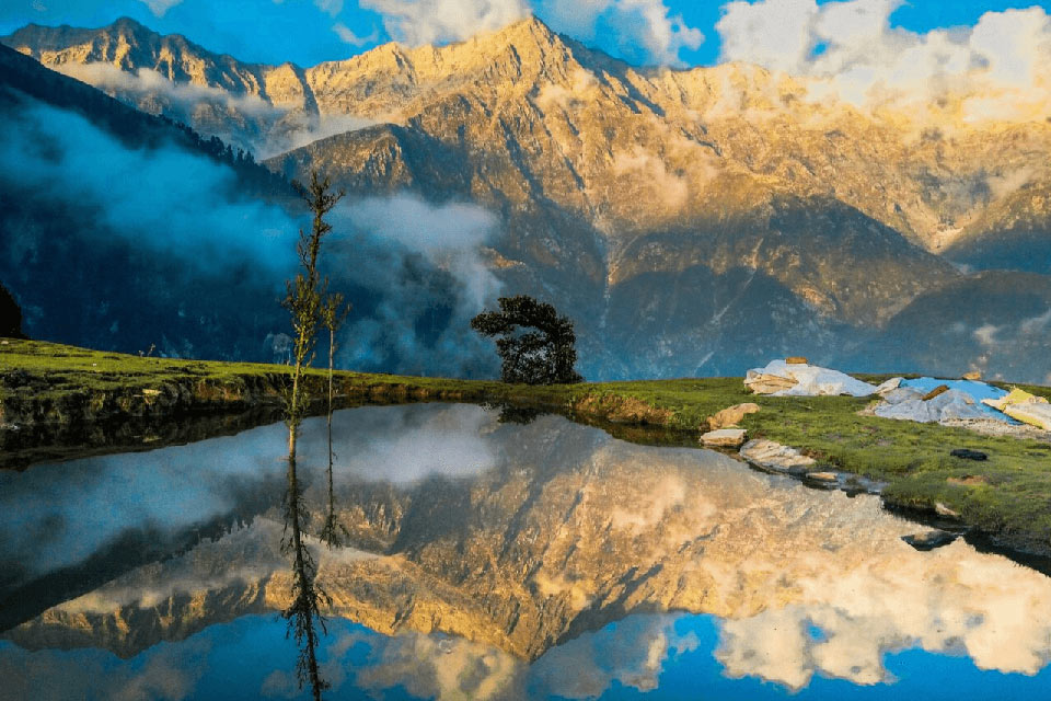 a small pond reflecting the beautiful himalayan mountains in triund